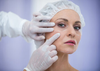 doctor-examining-female-patients-face-cosmetic-treatment