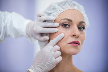 doctor-examining-female-patients-face-cosmetic-treatment